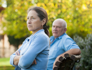 couple after quarrel sitting on   bench