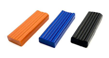 3 pieces of plasticine orange, blue and black isolated on white