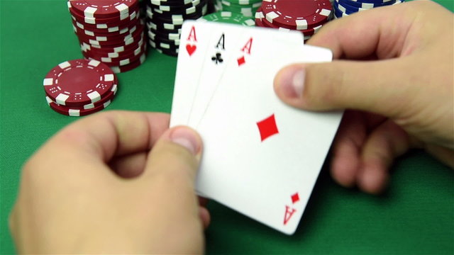 three ace in hand and poker chips stack
