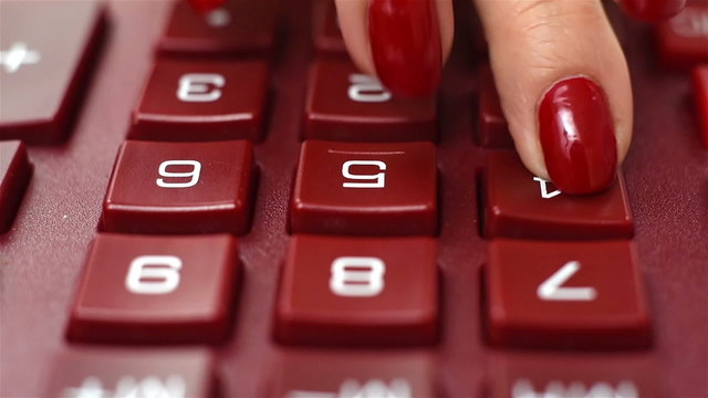 woman finger pushing calculator buttons, close up