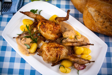 Two fried quail with gravy, gnocchi, rosemary