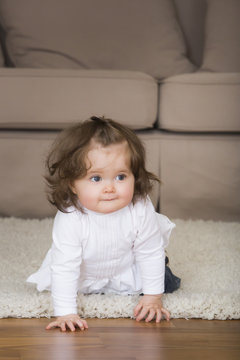 Little girl crawling on carpet