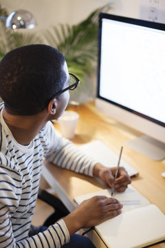 Young creative man working at computer in his home office