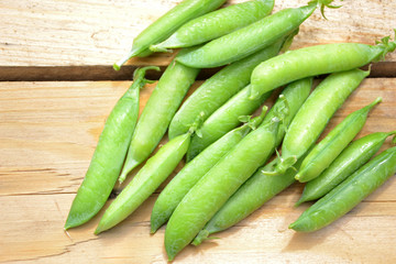 Fresh green peas on wooden background