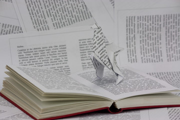 Origami dinosaur coming out of a book
