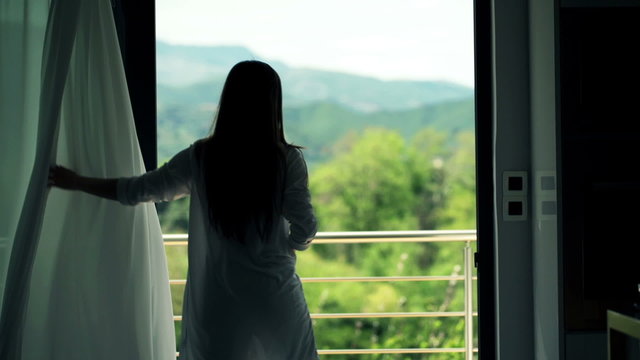 Woman Unveil Curtain And Stretching Her Arms Standing On Terrace 
