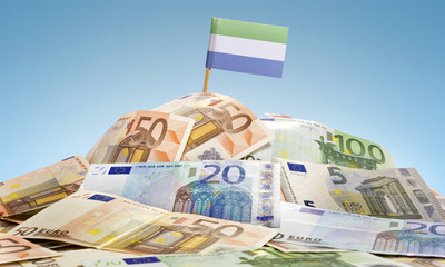 Flag of Sierra Leone sticking in a pile of various european bank