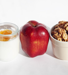 Nutritious and healthy breakfast with an apple, walnuts and natural yogurt