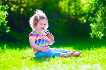Little girl eating ice cream in the garden