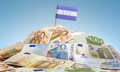 Flag of Honduras sticking in a pile of various european banknote