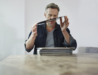 Mature man scrutinizing old vinyl records