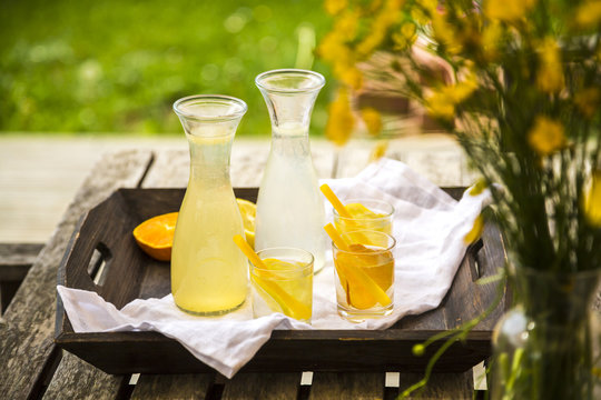 Tablet with carafes and glasses of homemade lemonade and orangeade