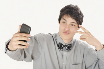 Happy businessman taking a selfie photo with his smart phone. Conceited elegant man holding mobile phone signing victory. 