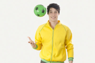 Young man throwing a football ball. Attractive man playing with a ball in the hands.