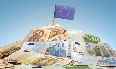 Flag of Europe sticking in a pile of various european banknotes.