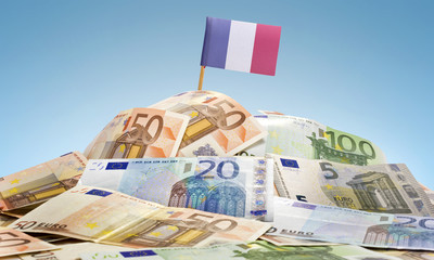 Flag of France sticking in a pile of various european banknotes.