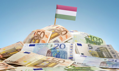 Flag of Hungary sticking in a pile of various european banknotes