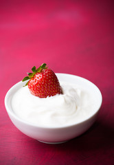 Strawberry in a bowl with cream