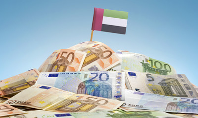 Flag of United Arab Emirates sticking in a pile of various europ
