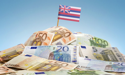 Flag of Hawaii sticking in a pile of various european banknotes.