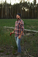 Fototapeta premium Portrait of bearded Lumberjack with Hat, Shirt and Ax