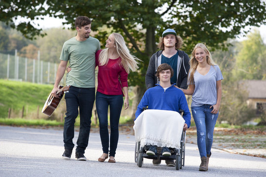 Young man in wheelchair with friends