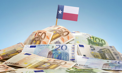 Flag of Texas sticking in a pile of various european banknotes.(