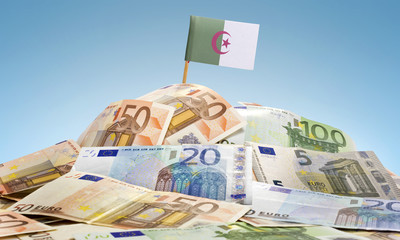 Flag of Algeria sticking in a pile of various european banknotes