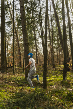 Young man jogging on forest path