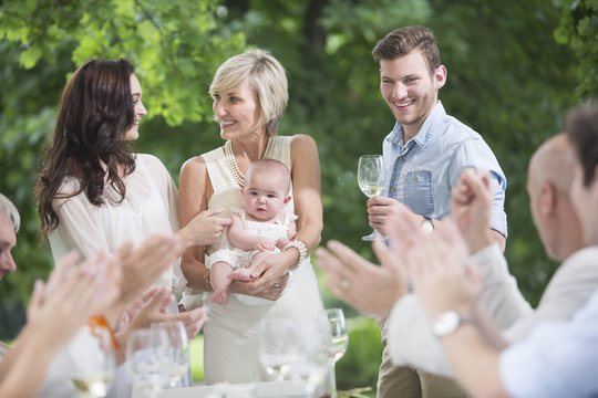 Baby being introduced to family on a garden party