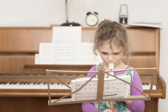 Girl at music stand playing recorder