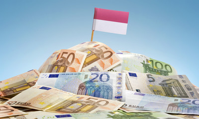 Flag of Monaco sticking in a pile of various european banknotes.