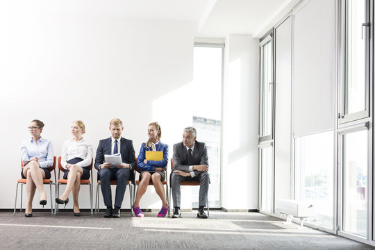 People sitting in a row, waiting for job interview