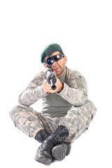 Young soldier with beret and glasses holding an automatic gun