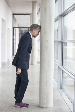 Frustrated businessman leaning against column