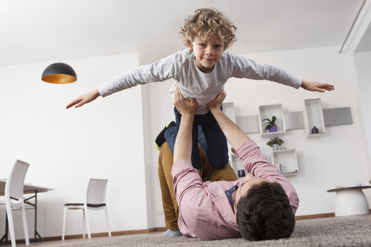Father playing with son at home