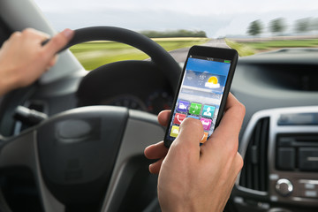 Person's Hand Using Cellphone While Driving A Car
