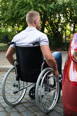 Man In Wheelchair Next To His Car