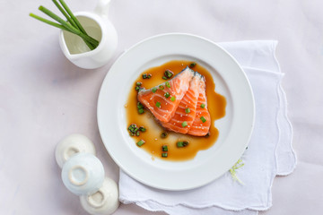 salmon fillet with sauce on white dish