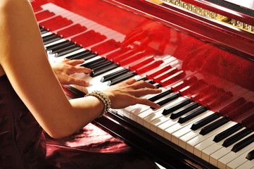 グランドピアノを弾く女性の手