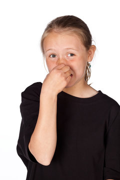 Studio portrait of a young girl holding her nose isolated on whi