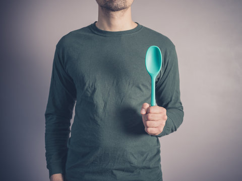 Young man holding a rubber spoon