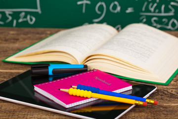 Back to school - blackboard with pencil-box and school equipment on table