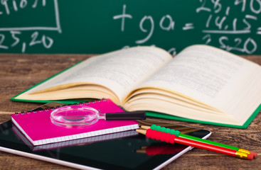 Back to school - blackboard with pencil-box and school equipment on table
