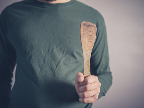 Young man with wooden spatula
