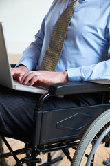 Disabled Businessman In Wheelchair Using Laptop