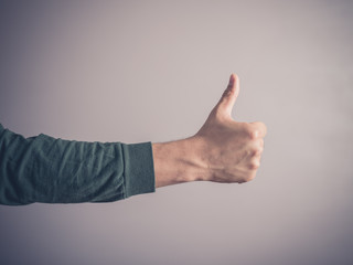 Young man giving thumbs up