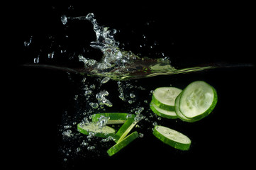 Fototapeta na wymiar Sliced cucumber splashing water