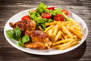 Poster Grilled chicken legs with chips and vegetables  © Jacek Chabraszewski