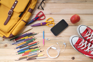 Outfit of traveler, student, teenager, young woman or guy. Overhead of essentials for modern young person. Different objects on wooden background.
